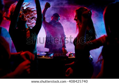 Ecstatic dj and dancers Royalty-Free Stock Photo #408425740
