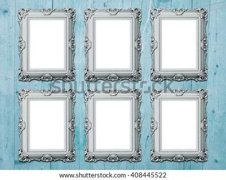 Close-up of six metal Baroque blank picture frames on aqua wooden background