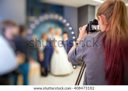 Girl photographer with a camera to shoot the wedding video