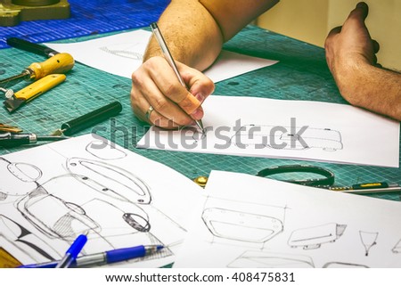 leather workshop master making sketches and workpiece