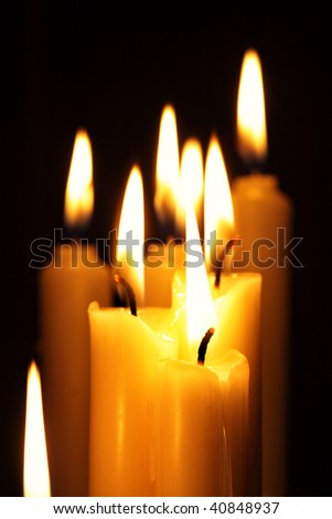 Burning candles close-up over a black background