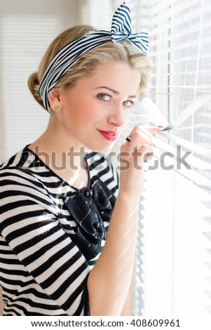closeup picture of beautiful blond young woman pinup girl having fun happy smiling and looking excited through sun lighted windows