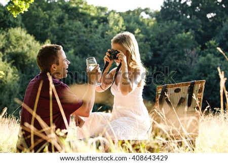 A young woman taking a picture of her boyfriend