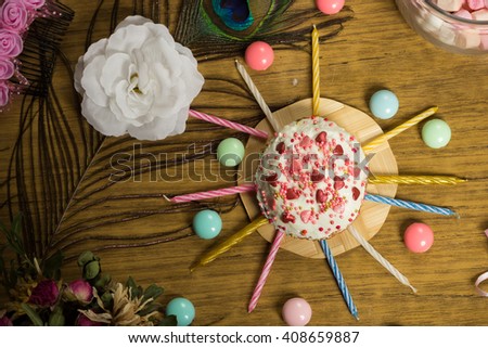 Celebrating sweet cupcake, candles on wooden table, candies, birthday party preparation, celebration food photo