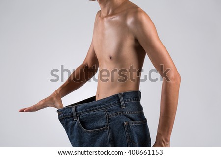 Man topless in big over-sized of jeans for diet success lose my weight concept, isolated on background