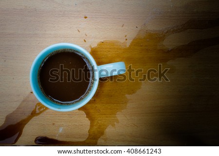 Still life cup of coffee spilled out on wooden desk Royalty-Free Stock Photo #408661243