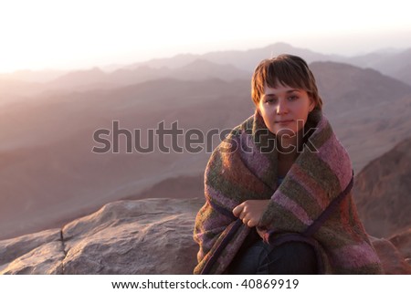 The girl watches the sunrise from the top of Moses Mountain. Mount Sinai is said to be the place where Moses received the Ten Commandments from God.