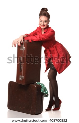 beautiful girl with a suitcase on a white background . stylish hair and stylish make-up. bright emotions. pin-up gir