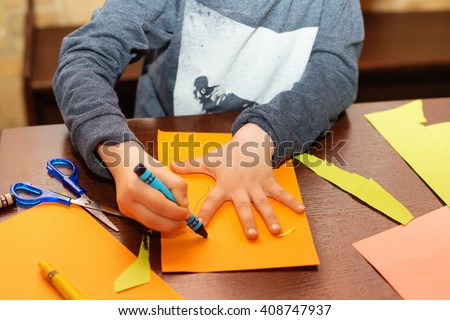 Child trace around a hand on paper with crayons. A simple drawing of a child's hand. Trace child palm. Hand Tracing. Children's creativity. Royalty-Free Stock Photo #408747937