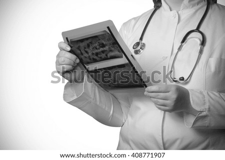 Doctor with X-ray picture in hands on a white background. Selective focus. Toned.