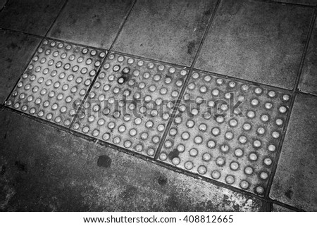 Background of Tactile paving for blind handicap on dirty grunge cement floor  - Black and White