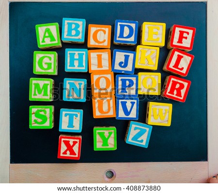 Wooden alphabet blocks with letters on wooden board