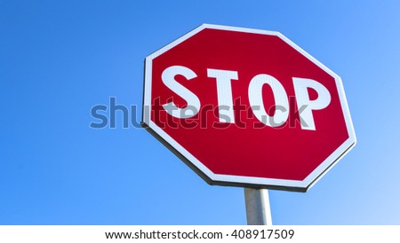 Forefront of a stop sign with a clear blue sky