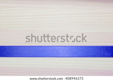blue ribbon strip on the light wooden background 