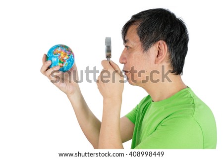 Asian Chinese Man Looking At Globe Through Magnifying Glass in isolated White Background