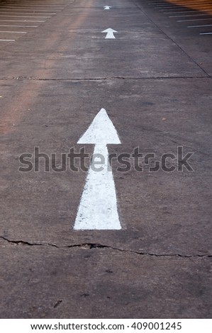White arrow forward traffic sign on road