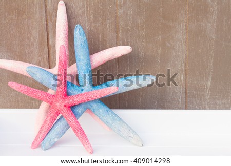 red and blue starfish  on gray wooden planks background