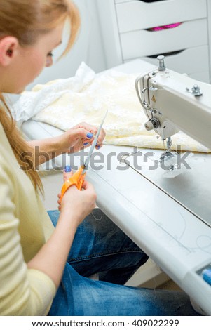 beautiful woman seamstress sew on the sewing machine clothes. sewing workshop