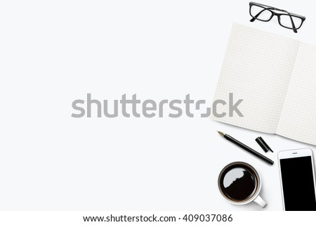 White desk with grid lined notebook and other supplies. Top view with copy space.