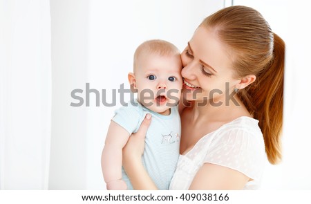 happy family mother playing  with newborn baby