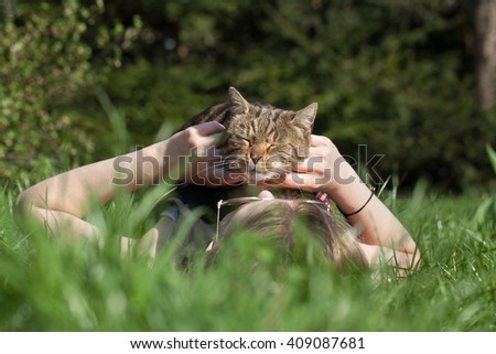 girl  petting cat  in the garden
