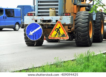 Road works. Excavator with roadworks sign
