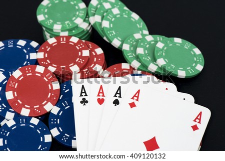 Playing card and fiches on black table, four a kind aces