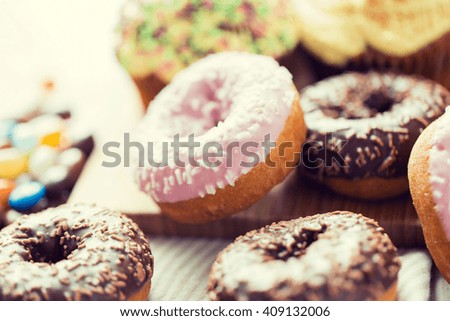 food, junk-food and eating concept - close up of glazed donuts on table