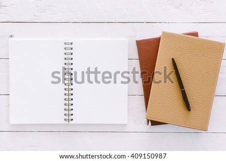Open blank notepad with empty white pages on wooden table
