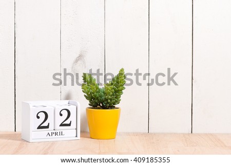 Earth Day, save the date white block calendar, April 22, with ornamental plants in flowerpots against a white wooden background. Royalty-Free Stock Photo #409185355