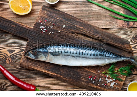 Delicious fresh sea fish on dark wooden background. Healthy food, diet or cooking concept
