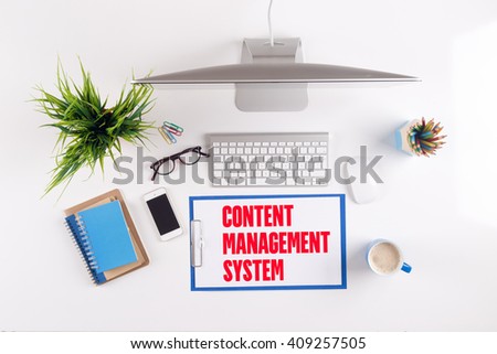 Office desk with CONTENT MANAGEMENT SYSTEM paperwork and other objects around, top view