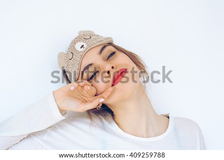 beautiful smiling model wearing a sleep mask on white