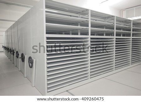 Art history museum depository warehouse archive empty grey shelves and storage space. Royalty-Free Stock Photo #409260475