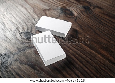 Blank white business cards on a dark wooden background. Mockup for branding identity. Blank template for graphic designers portfolios.