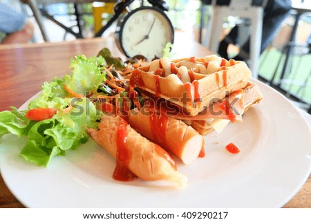 breakfast waffle,sausage with alarm clock on wooden table