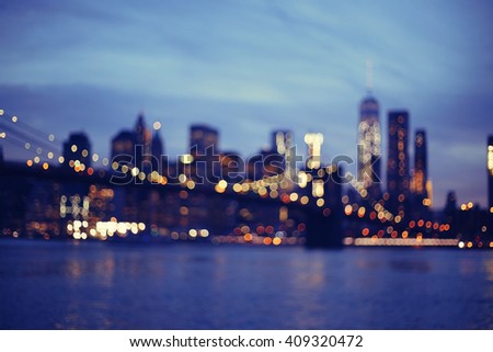 Out of focus view of Brooklyn Bridge at sunset, Downtown Manhattan, New York.Night scene. Light trails. City lights. Urban living and transportation concept