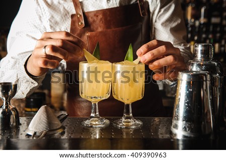 Barman is decorating cocktail with lemon no face Royalty-Free Stock Photo #409390963