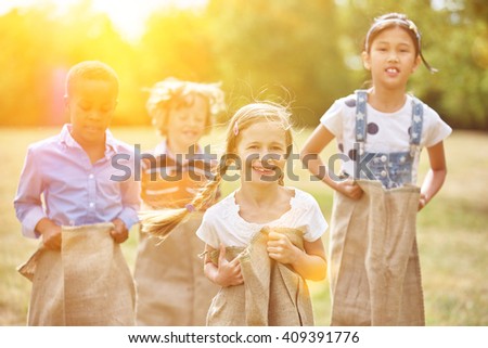 Group of kids at sack race smiling and having fun