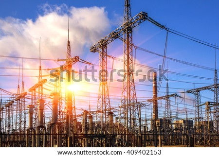 high-voltage lines against the background of electrical distribution stations at sunrise. Royalty-Free Stock Photo #409402153