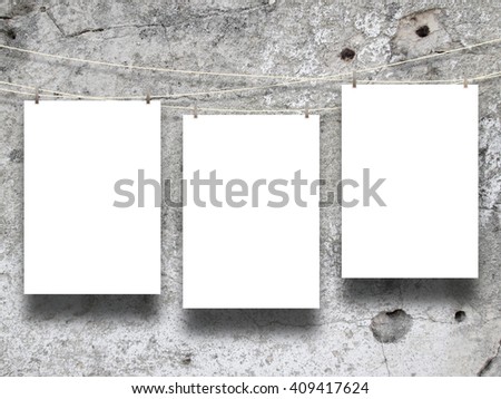 Close-up of three asymmetrical blank frames hanged by pegs against scratched concrete wall background
