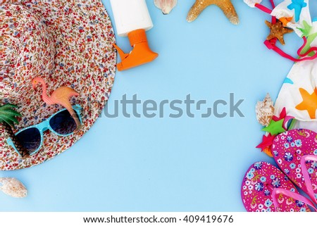 Colorful summer beachwear, flip flops, hat, sunglasses and starfish on blue background