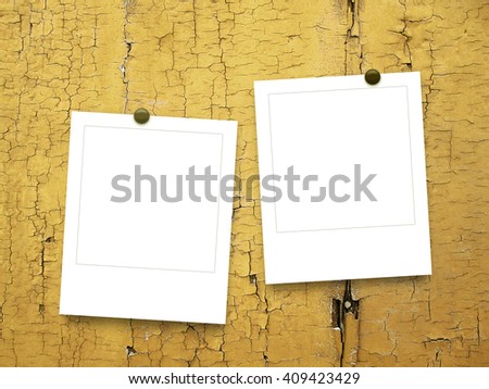 Close-up of two blank instant photo frames with pins on wooden boards background