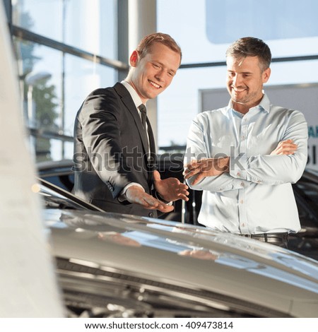 Smiling car salesman with customer