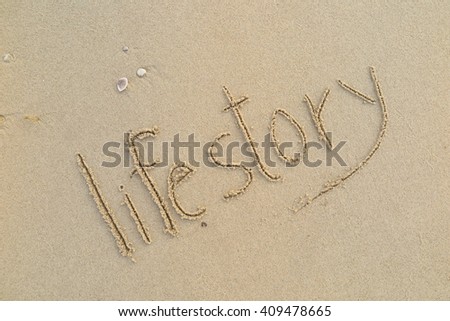 written words "life story" on sand of beach Royalty-Free Stock Photo #409478665