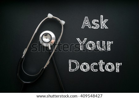 Medical Concept-Ask Your Doctor words written on black background with Stethoscope