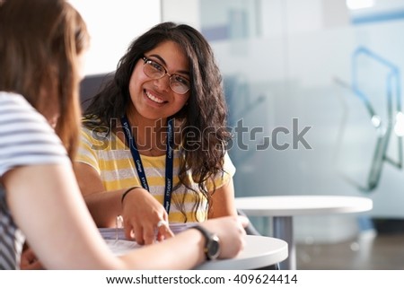 Two teenage girls working together in class Royalty-Free Stock Photo #409624414