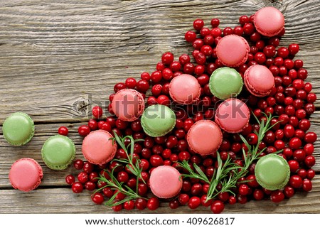 Macaroons with cranberries on wooden background 
