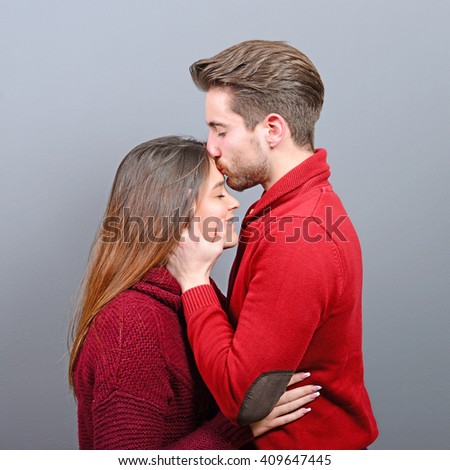 Young man kisses a woman in the forehead