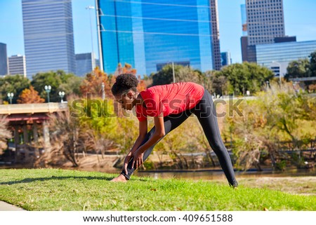 Runner girl stretching listening music earphones in the city park